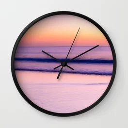 A wall clock featuring a serene purple and pink sunset, evoking post travel blues.