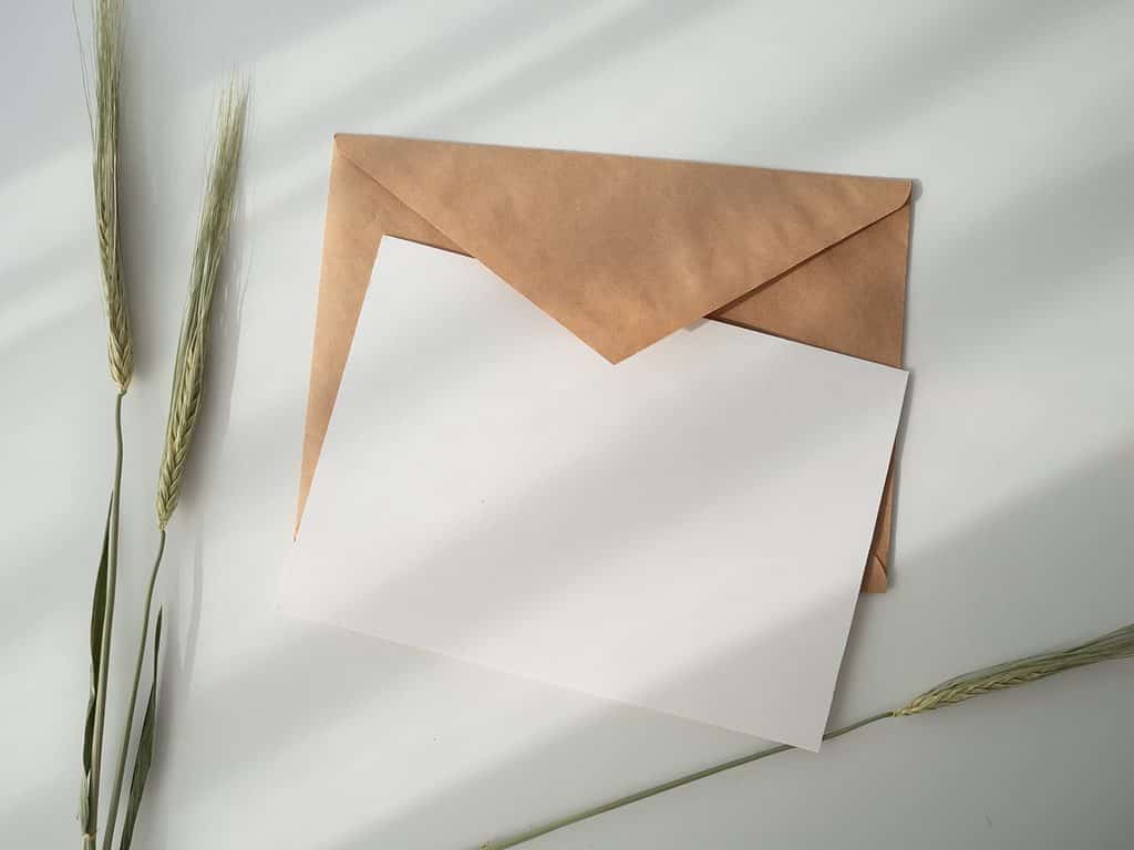 An envelope with a blank sheet of paper on a white surface.
