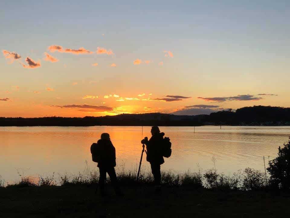 two friends photographing sunrise - solo travel fun