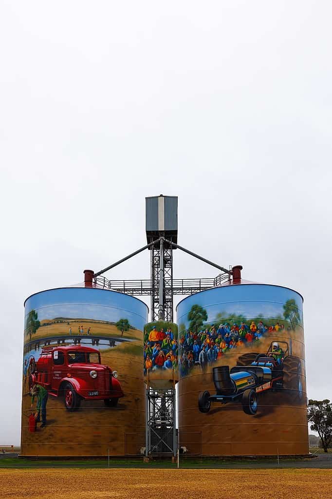 A silo featuring an edited painting of a truck and a car.