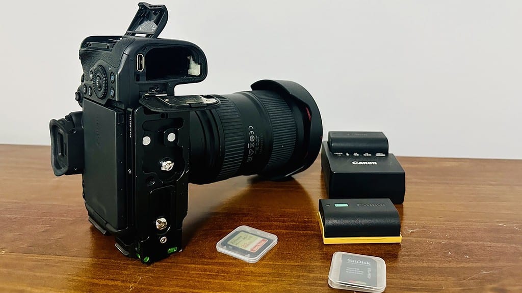 Image of camera with spare battery on charger and memory cards