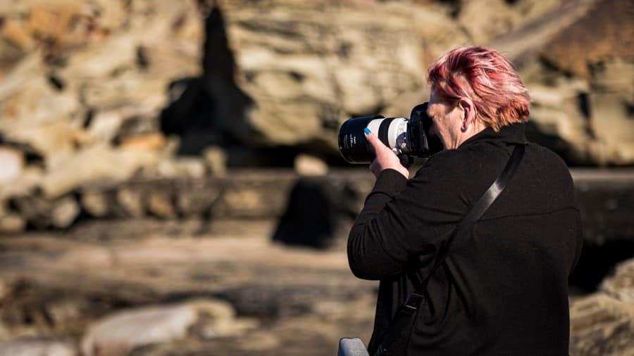 Woman taking photo handheld - elbows tucked in to ensure sharp photo